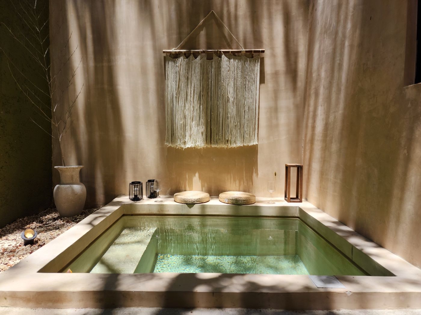 Bassin de spa calme dans une cour baignée de lumière